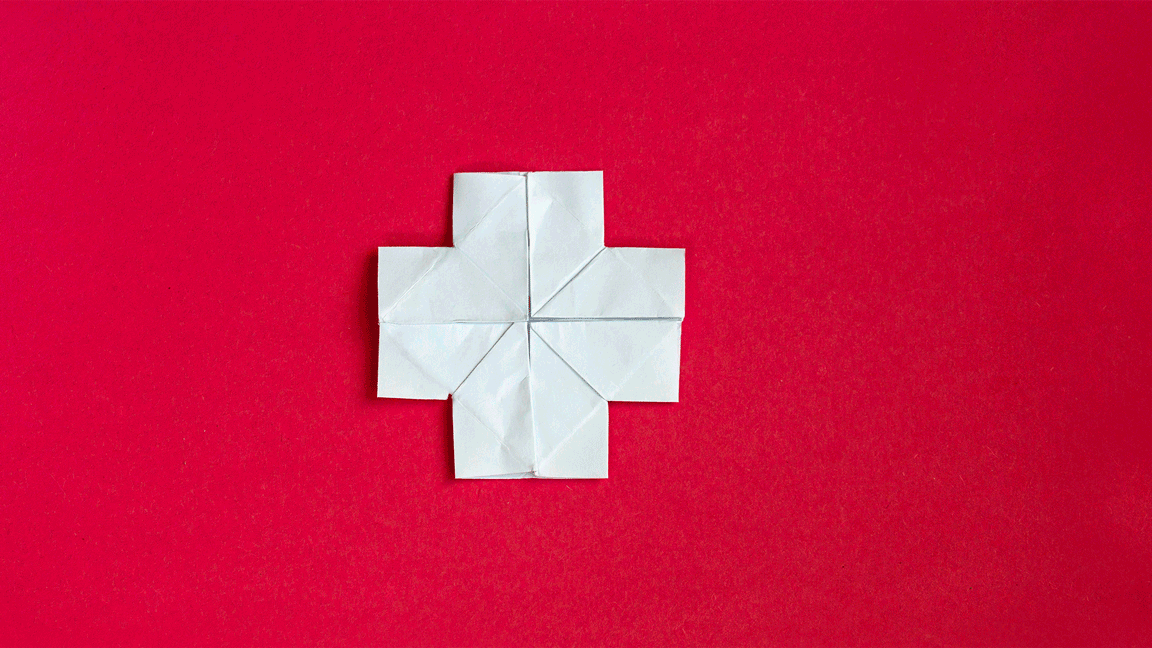 GIF of white origami cross being folded on a red background