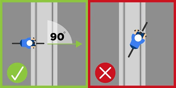 green checkmark for biker crossing tracks at 90-degree angle. Red X for biker crossing at lower angle